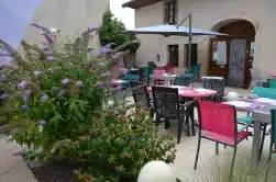 Terrasse avec chaises tables et parasol à l'Auberge du tilleul.